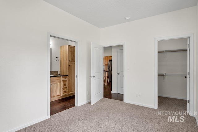 316 N 11th St, Payette, ID 83661 - unfurnished bedroom featuring dark carpet, a spacious closet, a closet, and ensuite bathroom