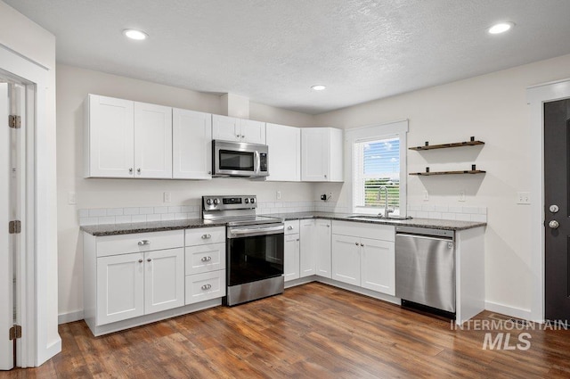 316 N 11th St, Payette, ID 83661 - kitchen with appliances with stainless steel finishes, dark wood-style flooring, white cabinets, recessed lighting, and dark stone counters