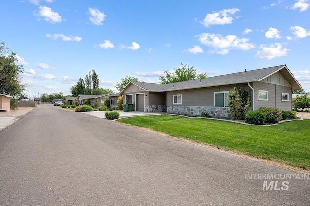 316 N 11th St, Payette, ID 83661 - view of front facade featuring an attached garage, stone siding, concrete driveway, board and batten siding, and a front yard
