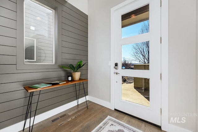 entryway featuring wood-type flooring and wooden walls