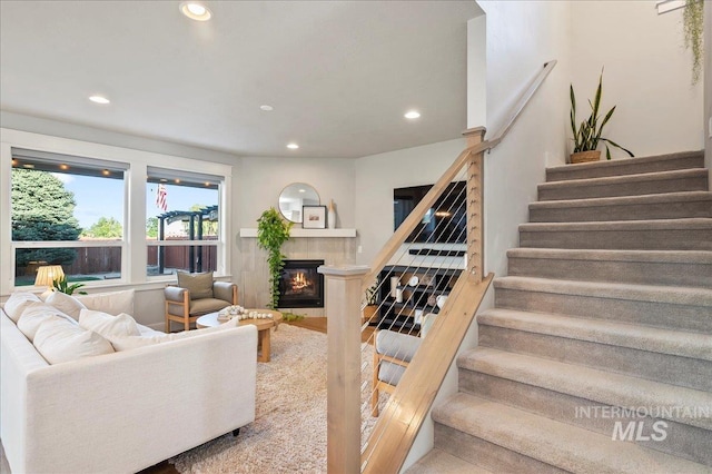 living room featuring stairway, a tiled fireplace, and recessed lighting