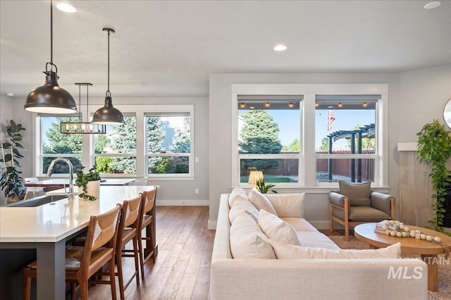 living area with recessed lighting, baseboards, and light wood finished floors