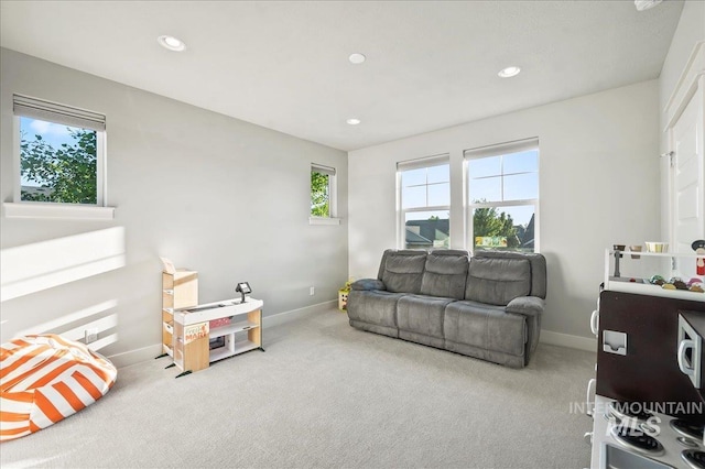 carpeted living area featuring a healthy amount of sunlight, baseboards, and recessed lighting