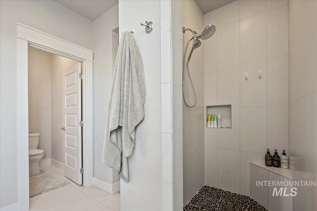 full bathroom with tile patterned flooring, toilet, and a walk in shower