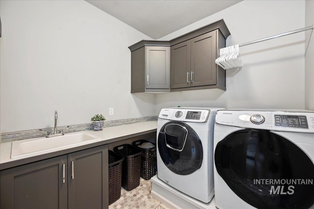 laundry area with cabinet space, a sink, and washer and clothes dryer