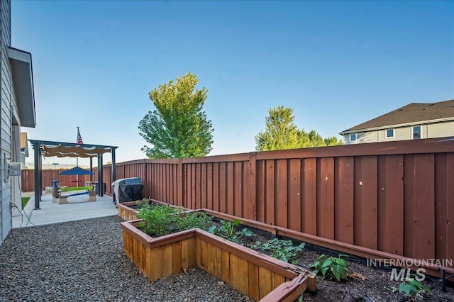 view of yard featuring a patio area, a fenced backyard, and a garden