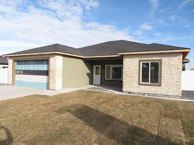 view of front of house featuring stone siding, roof with shingles, an attached garage, fence, and a front yard