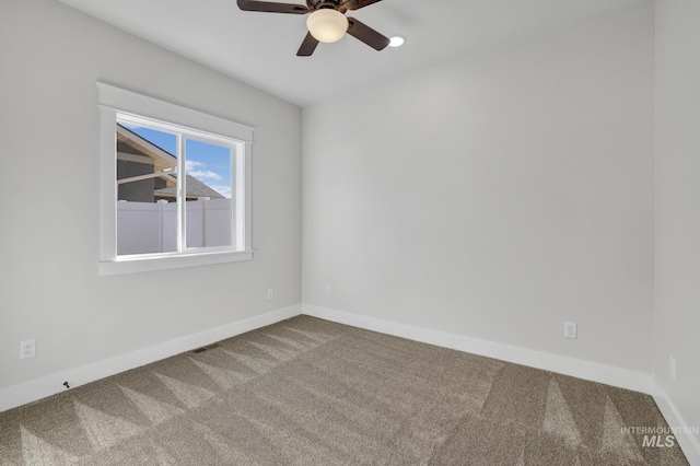 empty room featuring ceiling fan, carpet floors, visible vents, and baseboards