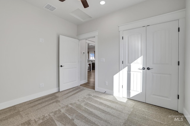 unfurnished bedroom with baseboards, attic access, visible vents, and carpet flooring