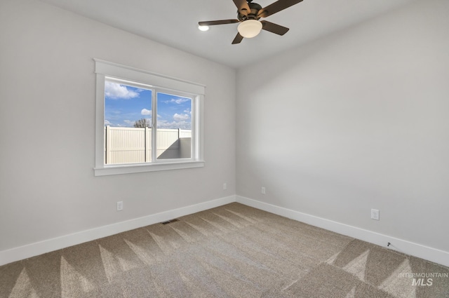 carpeted empty room with ceiling fan, visible vents, and baseboards