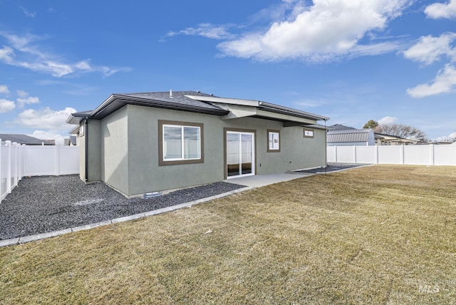 back of property with a patio, a lawn, a fenced backyard, and stucco siding