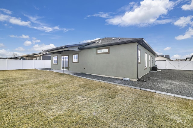 rear view of property with a patio, stucco siding, a lawn, cooling unit, and a fenced backyard