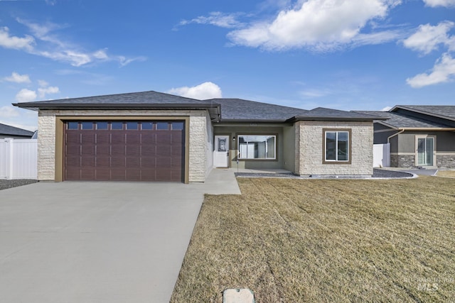 prairie-style home featuring an attached garage, stone siding, and a front lawn