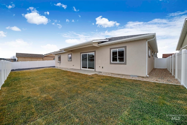 back of property with a fenced backyard, a patio, a lawn, and stucco siding