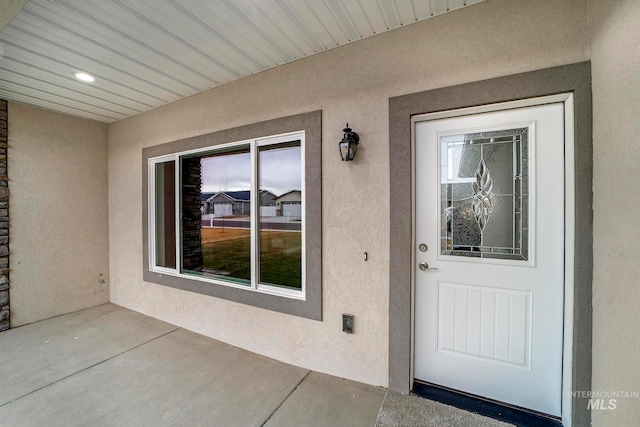 view of exterior entry featuring stucco siding