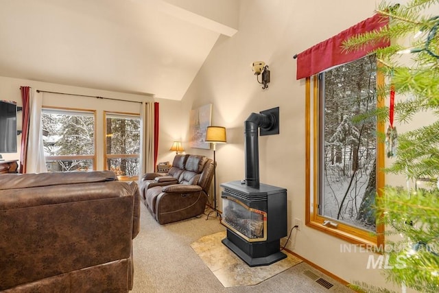 carpeted living room featuring high vaulted ceiling and a wood stove