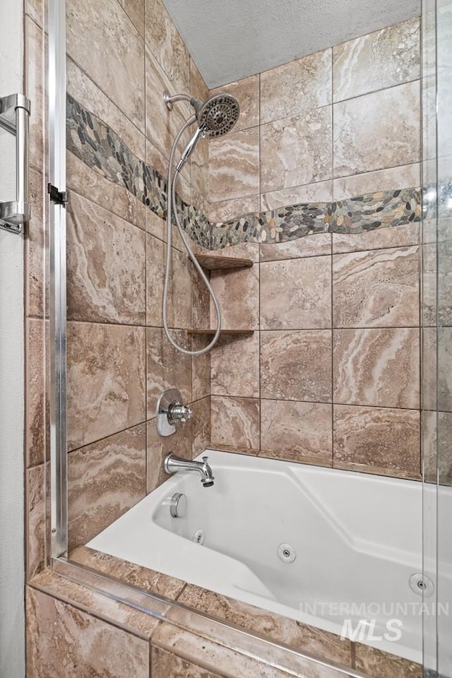 bathroom with tiled shower / bath and a textured ceiling