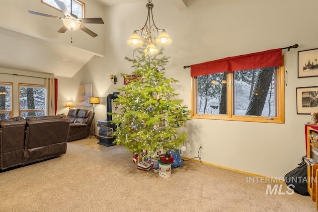 interior space with high vaulted ceiling, ceiling fan with notable chandelier, and carpet flooring