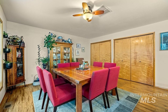 dining space with ceiling fan and wood-type flooring