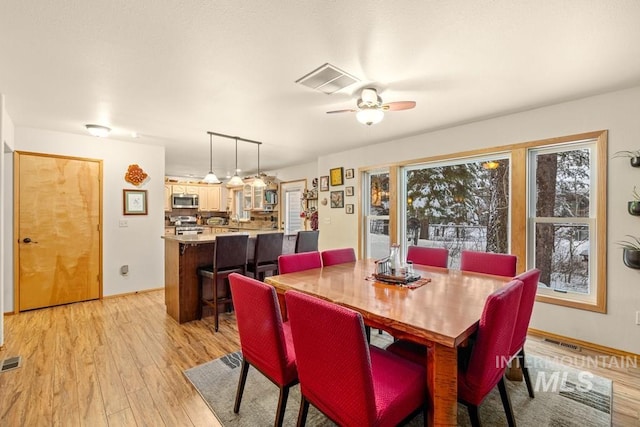 dining area with ceiling fan and light hardwood / wood-style floors