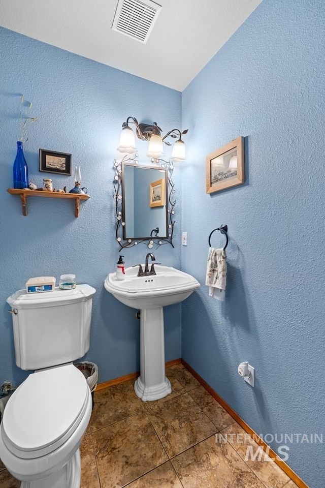 bathroom with toilet and tile patterned flooring