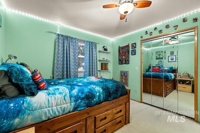 carpeted bedroom with ceiling fan and a closet