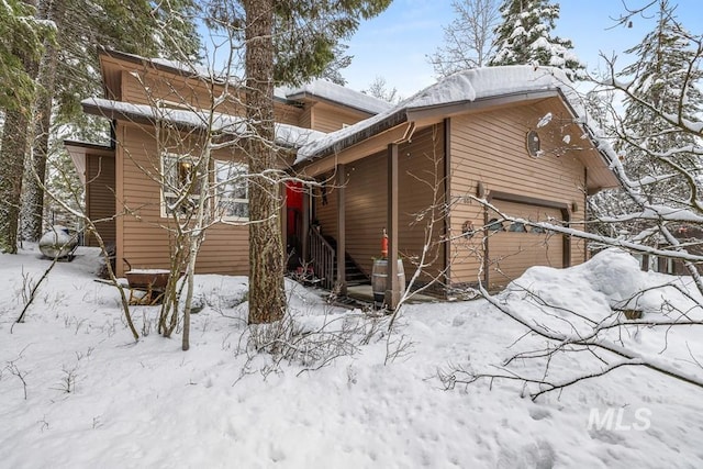 view of snowy exterior featuring a garage