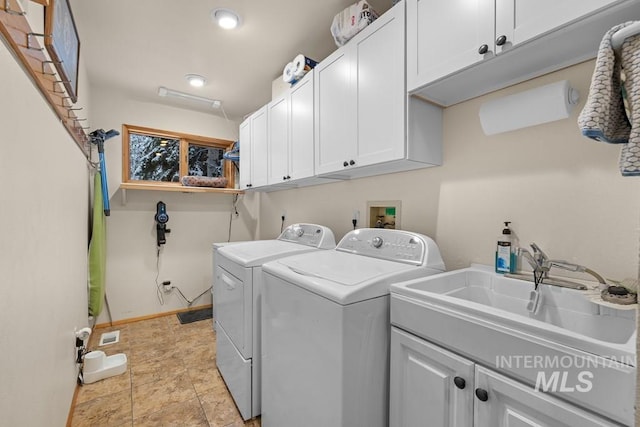 washroom featuring cabinets, washing machine and clothes dryer, and sink