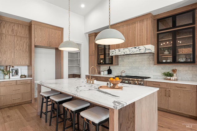 875 Creekwater, Eagle, ID 83616 - kitchen with tasteful backsplash, a breakfast bar area, light wood-style flooring, light stone counters, and high vaulted ceiling