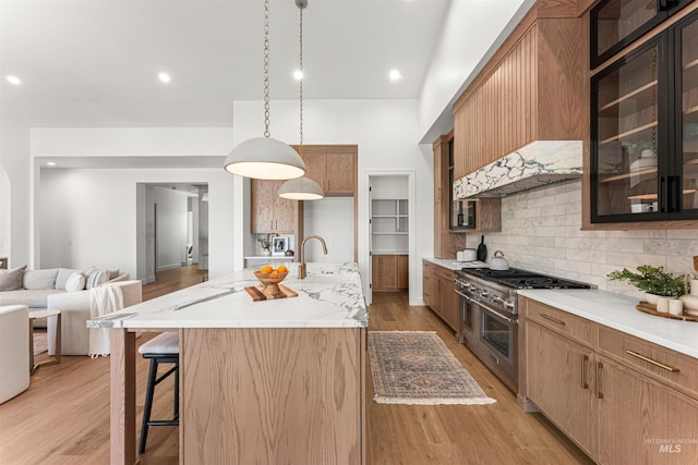 875 Creekwater, Eagle, ID 83616 - kitchen with range with two ovens, tasteful backsplash, glass insert cabinets, light wood-style floors, and a kitchen bar