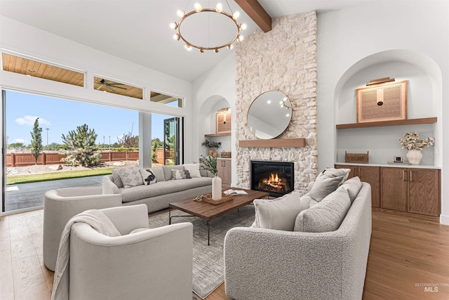 875 Creekwater, Eagle, ID 83616 - living room with light wood-style floors, a stone fireplace, beam ceiling, high vaulted ceiling, and a chandelier