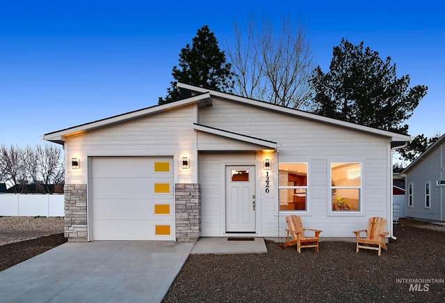 view of front of house featuring a garage, fence, and concrete driveway