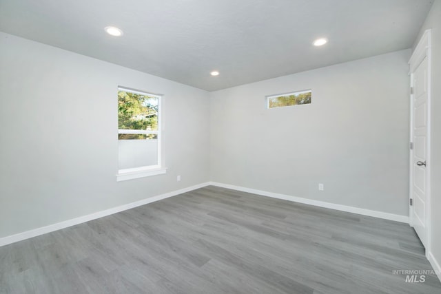 spare room with recessed lighting, wood finished floors, and baseboards