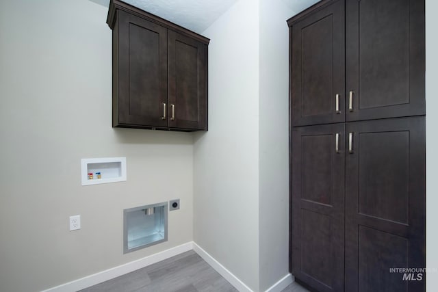 washroom featuring hookup for a washing machine, cabinet space, light wood-style floors, hookup for an electric dryer, and baseboards