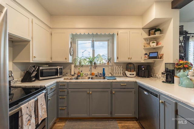 kitchen with gray cabinetry, white cabinetry, sink, and stainless steel appliances