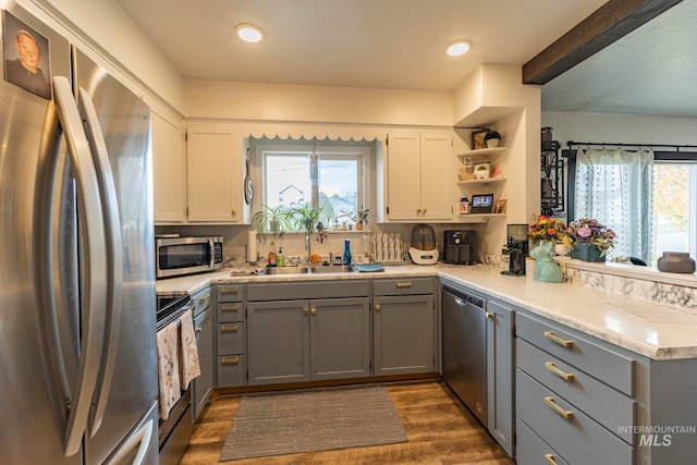 kitchen featuring gray cabinetry, white cabinetry, sink, dark hardwood / wood-style flooring, and appliances with stainless steel finishes