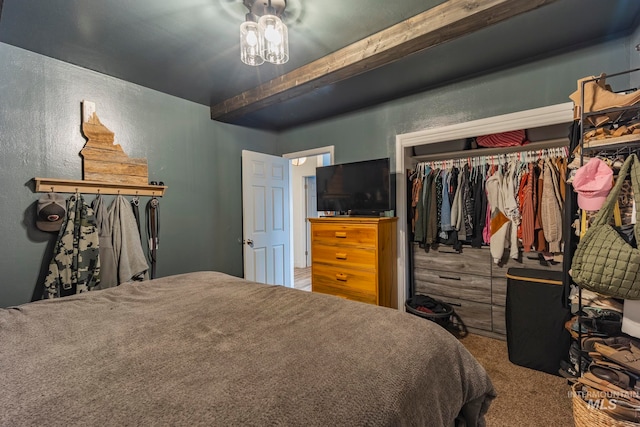 bedroom featuring carpet, beamed ceiling, and a closet