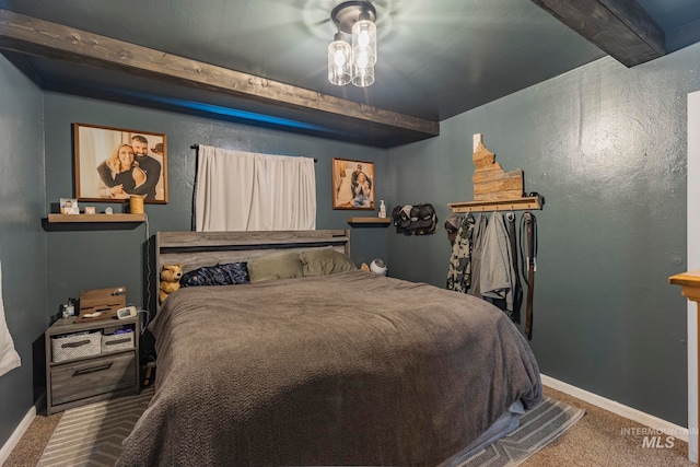 carpeted bedroom with beam ceiling