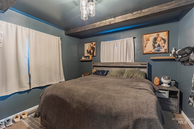 carpeted bedroom featuring beam ceiling