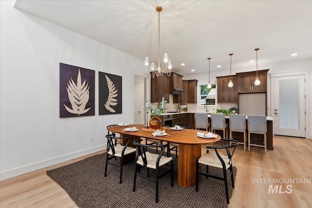 dining area featuring recessed lighting, a notable chandelier, light wood-style flooring, and baseboards