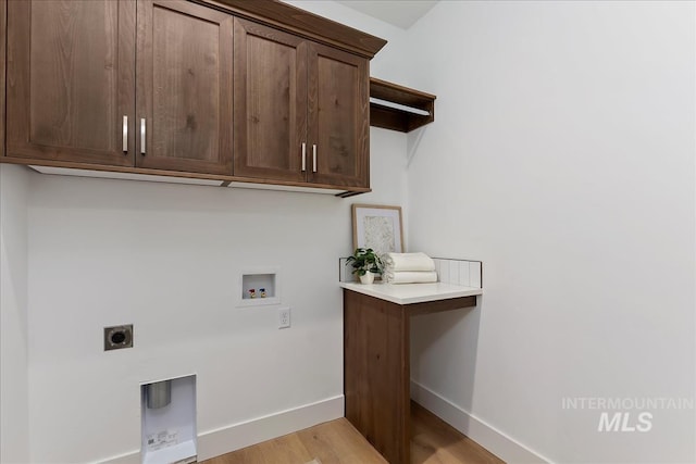 laundry room featuring hookup for an electric dryer, washer hookup, baseboards, light wood-type flooring, and cabinet space