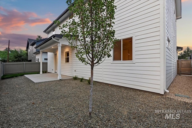 rear view of house with a fenced backyard and a patio