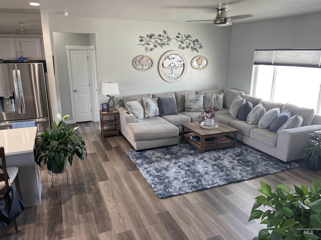 living area featuring ceiling fan and dark wood finished floors