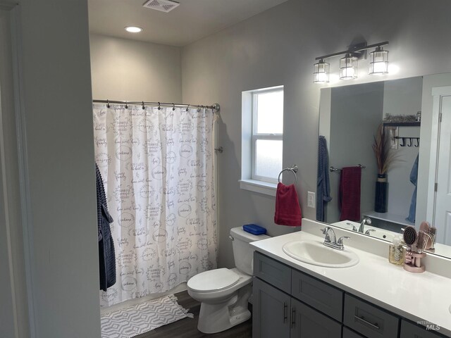 bathroom with vanity, curtained shower, toilet, and visible vents