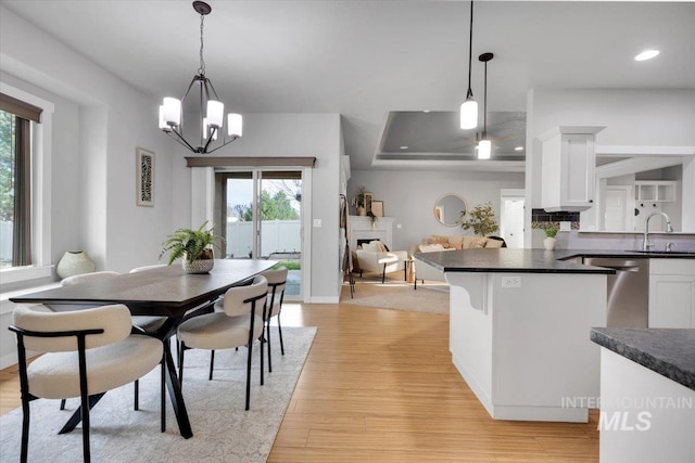 dining room featuring light wood finished floors, recessed lighting, a notable chandelier, and baseboards