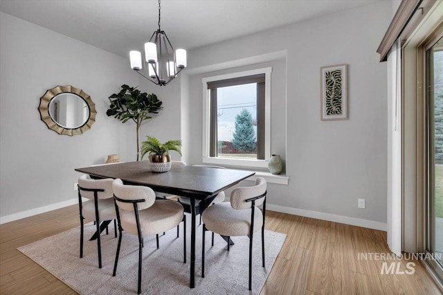 dining area featuring baseboards, a notable chandelier, and plenty of natural light