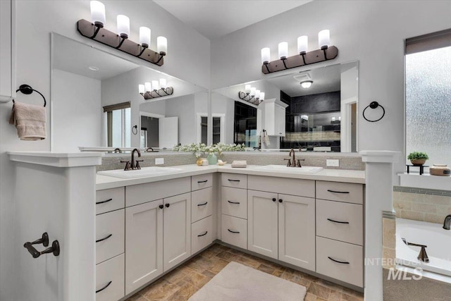 full bath featuring stone tile flooring, a shower stall, decorative backsplash, and a sink