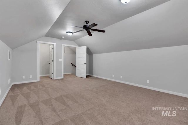 additional living space featuring baseboards, ceiling fan, lofted ceiling, and carpet flooring