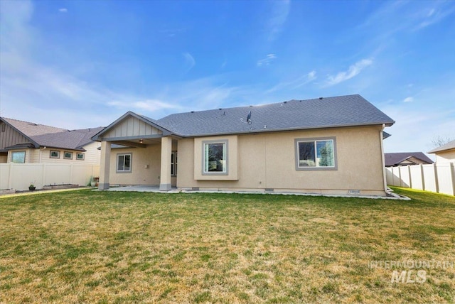 rear view of house featuring a patio, a lawn, stucco siding, and a fenced backyard