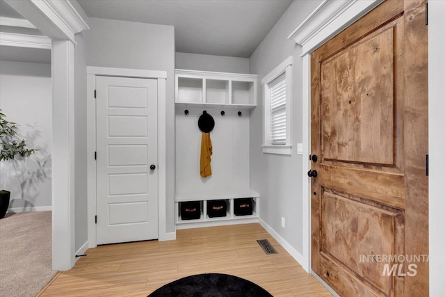 mudroom featuring visible vents, light wood-style flooring, and baseboards